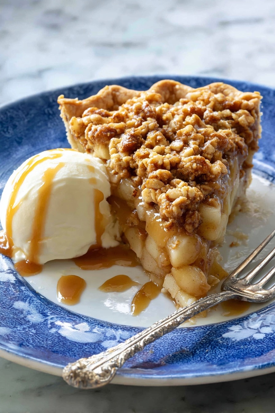 A slice of pie with three layers sits on a white plate with a blue pattern: the bottom is a light brown crust, the middle layer is soft apple chunks mixed with caramel sauce, and the top layer is a crumbly, golden brown oat topping with small pieces of nuts. Next to the pie is a scoop of white ice cream covered with caramel sauce. A silver fork with a twisted handle rests on the plate near the pie. The background has a white marbled texture. Photo taken with an iphone --ar 2:3 --v 7 - Apple Crisp Pizza, dessert pizza recipes, apple dessert ideas, easy fruit pizza, sweet baked pizza