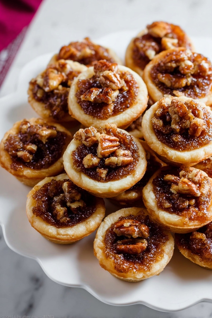 The image shows several small tartlets placed on a white marbled surface. Each tartlet has a golden-brown short crust base that looks crisp. Inside, there is a rich, bubbly filling made of dark brown caramelized nuts, mainly walnuts, giving a textured and slightly glossy look. The top layer is sprinkled with coarse white salt crystals, adding contrast and highlighting the nut filling. The tartlets are close together, showing a rustic and homemade feel with uneven edges and a warm, inviting color mix of golden crust and dark filling. photo taken with an iphone --ar 2:3 --v 7 - Mini Pecan Pies in Mini Muffin Pans, mini pecan pie recipe, bite-sized pecan pie treats, individual pecan tartlets, easy mini pecan desserts