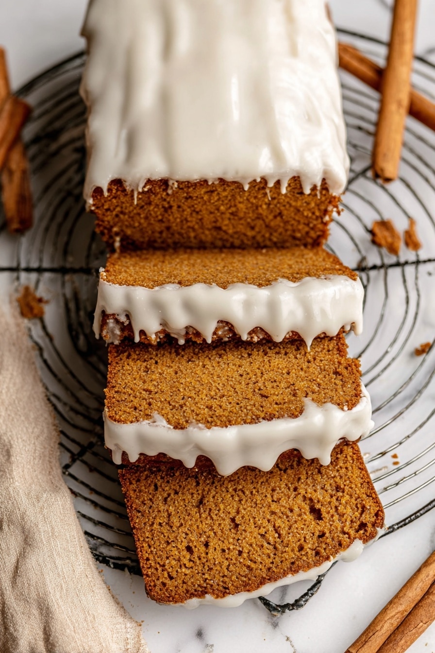 The image shows a loaf of brown cake with three slice pieces cut from it, stacked and spread out below the rest of the loaf. The top of the cake and the edges of the slices have a thick layer of white icing that looks smooth but slightly melted, dripping down the sides. The cake has a dense, moist texture with visible small holes inside. The loaf rests on a round metal wire cooling rack placed on a white marbled surface with a beige cloth and cinnamon sticks nearby. Photo taken with an iphone --ar 2:3 --v 7 - Healthy Pumpkin Bread with Maple Glaze, pumpkin bread recipes, healthy fall desserts, wholesome pumpkin loaf, maple glaze pumpkin bread