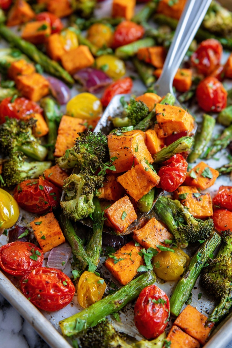 This image shows a close-up of a tray filled with roasted vegetables in layers. The first layer has bright orange sweet potato chunks with a slightly crispy texture. The second layer is made up of green asparagus spears and small broccoli pieces with roasted edges. The third layer consists of red and yellow cherry tomatoes, some whole and some cut in half showing their juicy inside. The vegetables are mixed together with small green herb leaves sprinkled on top. The background surface is a white marbled texture. A metal spatula is lifting a mix of these vegetables in the center of the image, with a woman's hand partly visible on the side. photo taken with an iphone --ar 2:3 --v 7 - Sheet Pan Roasted Vegetables, roasted vegetables recipe, easy vegetable side dish, healthy roasted vegetables, one-pan veggie roast