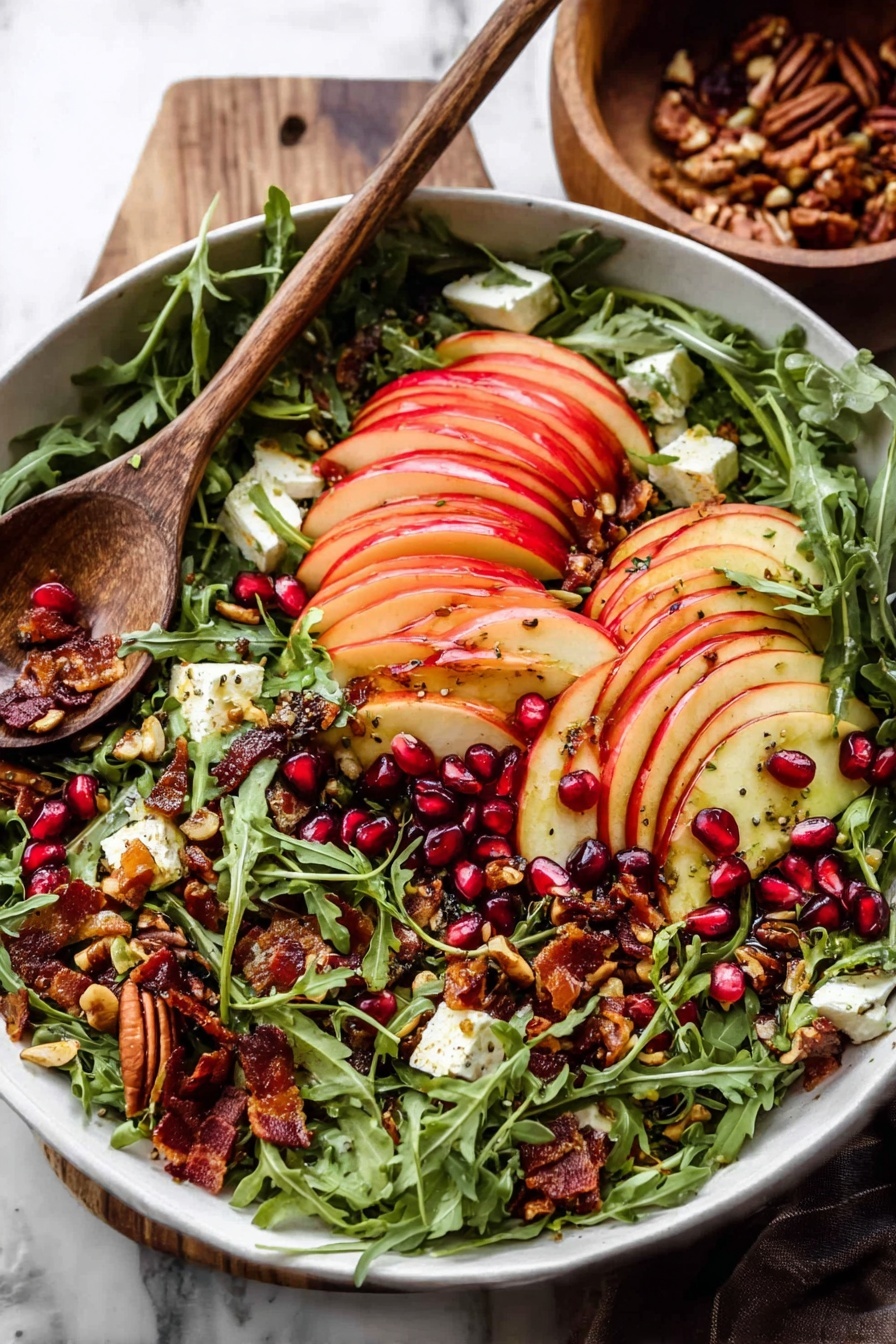 A white bowl filled with a fresh salad layered with bright green arugula leaves as the base, topped with thinly sliced red apple pieces arranged in neat rows across the top. Scattered among the arugula and apples are dark red pomegranate seeds, crunchy toasted seeds and nuts with a golden brown color, small chunks of creamy white cheese, and some crispy bacon bits with a deep reddish-brown hue. A wooden spoon rests on the side of the bowl, and the scene is set on a white marbled surface with a wooden bowl in the background. Photo taken with an iphone --ar 2:3 --v 7 - Autumn Harvest Honeycrisp Apple and Feta Salad, Honeycrisp Apple Salad, Fall Apple Salad with Feta, Easy Autumn Salad Recipes, Cozy Fall Salad Ideas