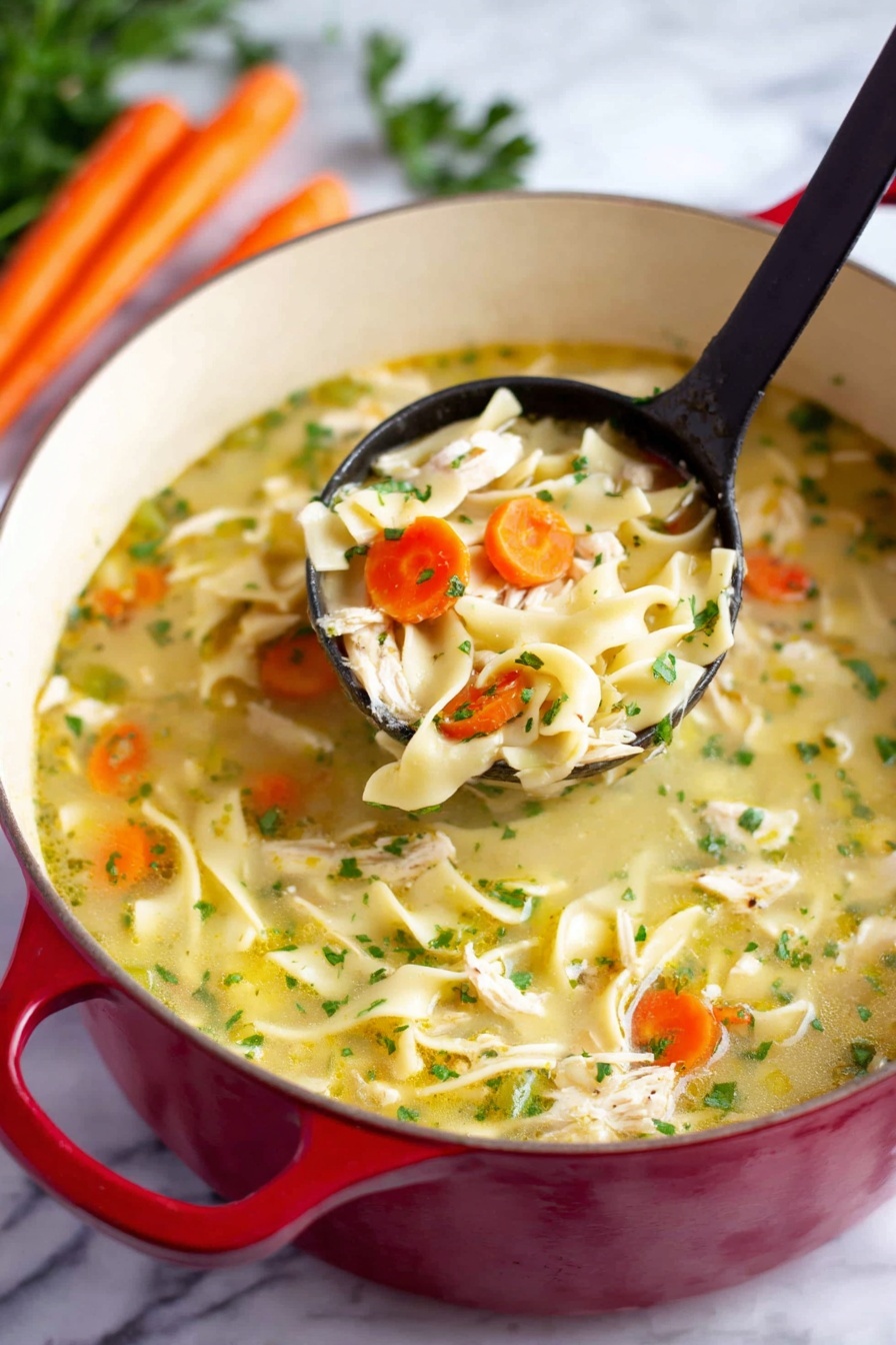 The image shows a red pot filled with chicken noodle soup placed on a white marbled surface. The soup has three main layers: a light yellow broth as the base with visible small green herbs scattered throughout; chunky pieces of white chicken and thick flat noodles spread evenly; and slices of orange carrot and green celery mixed in. A black ladle lifts a portion of soup, showing a close-up of a mix of chicken, noodles, carrot, and celery. In the background, there are some whole carrots and green parsley visible. Photo taken with an iphone --ar 2:3 --v 7 - Easy Chicken Noodle Soup, Chicken Noodle Soup recipe, comforting chicken soup, quick homemade chicken noodle, hearty chicken soup