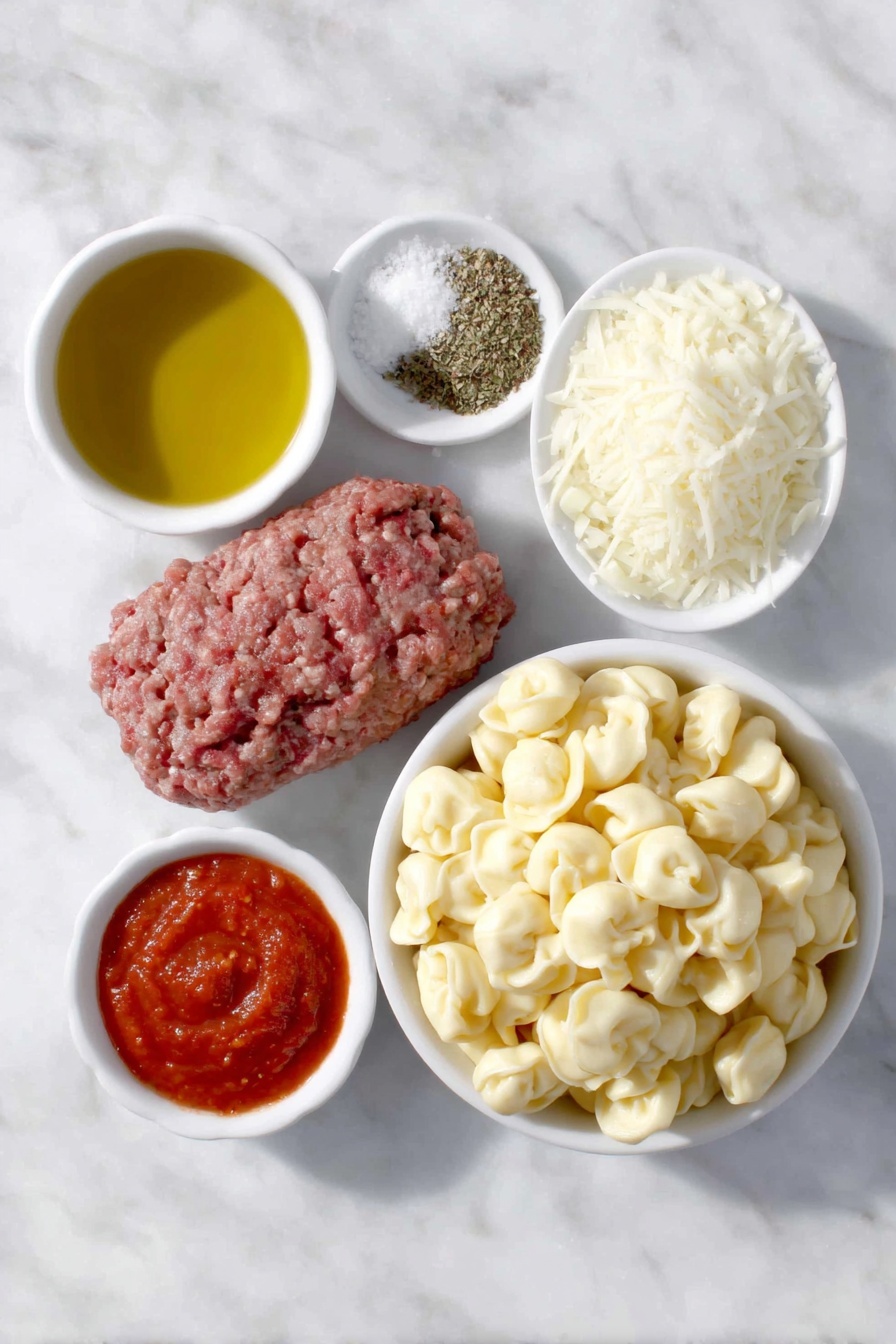 Flat lay of a small white ceramic bowl of golden olive oil, a handful of fresh lean ground beef, a small white ceramic bowl with diced white onion, three peeled garlic cloves, a small white ceramic bowl of crushed bright red tomatoes, a small white ceramic bowl of smooth red tomato sauce, a small white ceramic bowl containing dried Italian seasoning herbs, a small white ceramic bowl of kosher salt crystals, a small white ceramic bowl of freshly ground black pepper, a generous mound of fresh cheese tortellini pasta, and a small white ceramic bowl heaped with freshly grated mozzarella cheese, all arranged in perfect symmetry on a clean white marble surface, soft natural light, photo taken with an iPhone, professional food photography style, fresh ingredients, white ceramic bowls, no bottles, no duplicates, no utensils, no packaging --ar 2:3 --v 7 --p m7354615311229779997 - Baked Tortellini with Cheese, cheesy tortellini casserole, easy baked tortellini recipe, hearty cheese tortellini bake, family-friendly pasta casserole