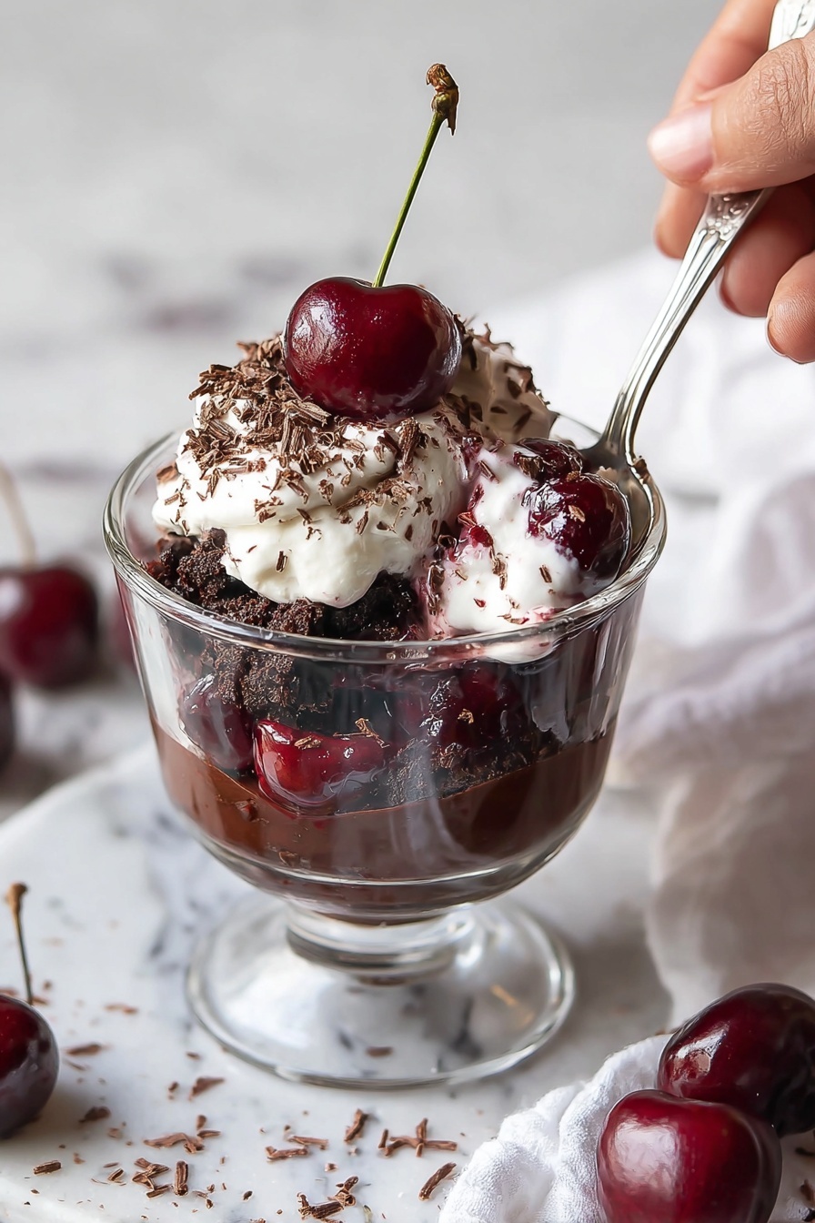 A glass trifle dish holds a layered dessert starting with a dark chocolate crumb base at the bottom, followed by a thick chocolate pudding layer. Above this is a white cream layer with swirls of red cherry sauce, then another dark chocolate crumb layer, and a second thick chocolate pudding layer. The top is covered with glossy cherry sauce and a generous layer of fluffy white whipped cream sprinkled with tiny chocolate shavings. Several fresh cherries with green stems sit on top, adding a shiny red contrast. The dish is on a white marbled surface with a small white bowl of chocolate shavings nearby, photo taken with an iphone --ar 2:3 --v 7 - Black Forest Cherry Trifle, Black Forest dessert, Cherry trifle recipe, Chocolate and cherry dessert, Easy trifle for parties