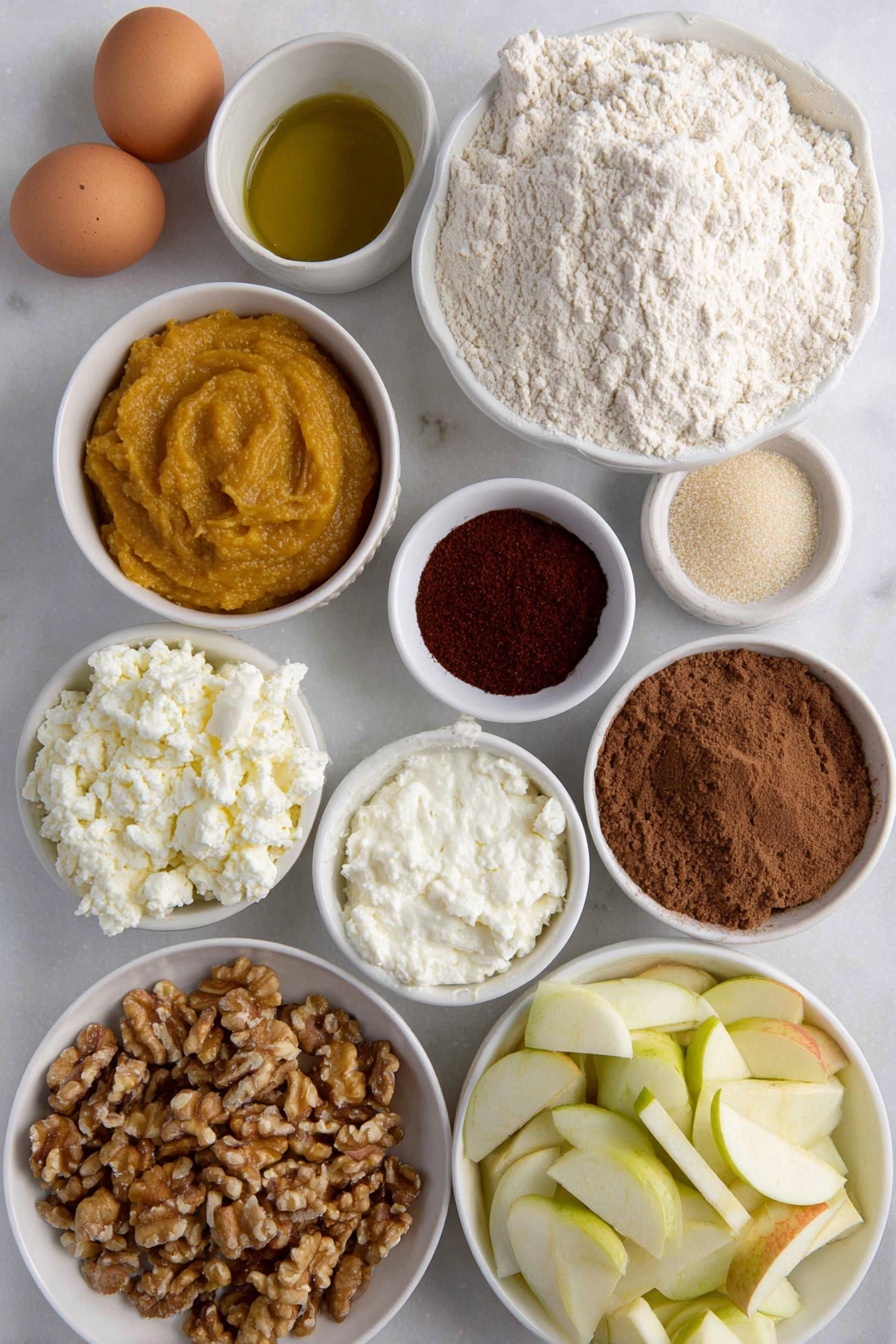 Flat lay of fresh all purpose flour in a small mound, a few brown eggs with smooth uncracked shells, a glistening golden olive oil pool in a small white ceramic bowl, vibrant orange pumpkin puree in a small white bowl, creamy white ricotta cheese dollop in a small white bowl, finely grated pale parmesan cheese in a small white bowl, rustic brown sugar crystals in a small white bowl, ground cinnamon and allspice powders gently mounded side by side, bright red cayenne powder in a small white bowl, lightly cracked black pepper powder, a handful of fresh bright green sage leaves, diced Gala apple pieces showing red and cream hues in a small white bowl, small white bowl with pale apple cider vinegar, chopped walnuts with rough textured surface in a small white bowl, fresh uncooked sheet of pale ravioli dough laid flat with clean edges — no utensils or packaging, all ingredients arranged with perfect symmetry on a clean white marble surface, soft natural light, photo taken with an iPhone, professional food photography style, fresh ingredients, white ceramic bowls, no bottles, no duplicates, no utensils, no packaging --ar 2:3 --v 7 --p m7354615311229779997 - Pumpkin Ravioli with Apple Sage Butter, pumpkin ravioli, homemade ravioli, fall pasta recipes, apple sage butter