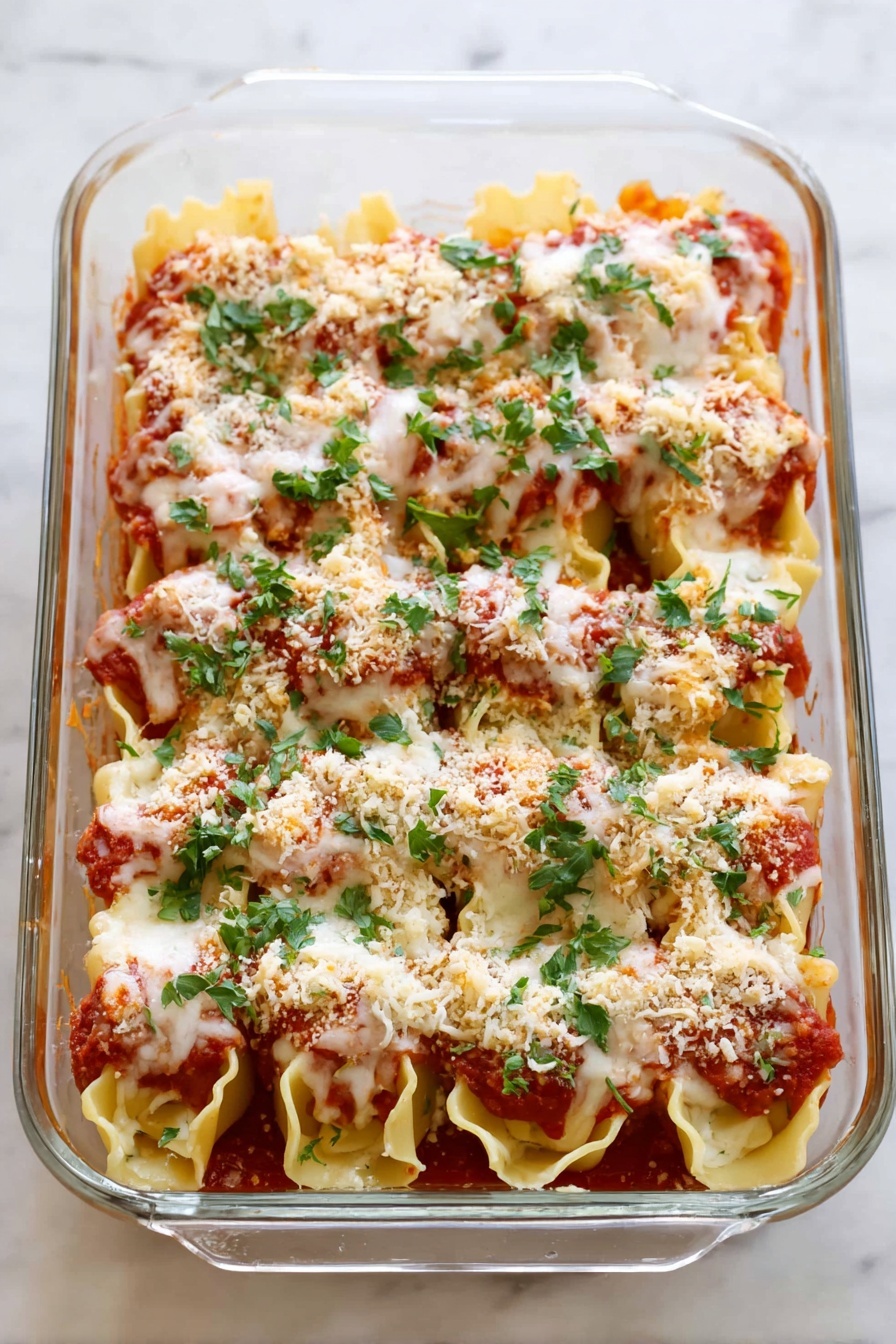 Three large pasta shells are arranged on a white plate with tomato sauce spread beneath them. Each shell is filled with a white cheese filling, topped with a layer of melted cheese that looks soft and lightly browned. A sprinkle of light brown breadcrumbs sits on top of the melted cheese, and fresh green parsley leaves are scattered over and around the shells, adding a bright touch. The plate rests on a white marbled surface. photo taken with an iphone --ar 2:3 --v 7 - Chicken Parmesan Stuffed Shells, Italian stuffed shells, baked chicken and pasta casserole, cheesy chicken stuffed shells, family dinner Italian recipes