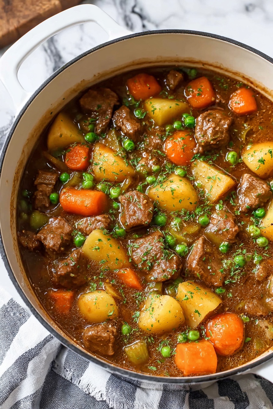 A white pot filled with a thick stew showing several layers: large chunks of brown meat, round orange carrot slices, yellow potato pieces, small green peas, and diced celery, all mixed in a rich brown sauce and lightly sprinkled with chopped green herbs on top. The pot sits on a white marbled surface with a striped gray and white cloth partially visible underneath. The colors of the stew ingredients contrast brightly with the white pot, making the dish look warm and hearty photo taken with an iphone --ar 2:3 --v 7 - Hearty Beef Stew, beef stew recipe, comforting beef stew, tender beef stew, cozy stew