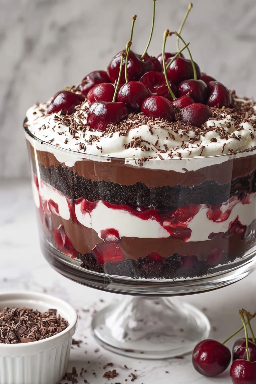 A clear glass dessert cup shows a layered cherry chocolate dessert. The bottom layer is dark chocolate pudding with whole cherries visible through the glass. Above this is a mix of cherry sauce and small chunks of dark chocolate cake. On top, there is a thick layer of white whipped cream sprinkled with dark brown chocolate shavings. Two whole cherries, one with a long stem, sit on the whipped cream. A woman's hand holds a spoon digging into the dessert. The scene is set on a white marbled surface with whole cherries and a white cloth nearby. Photo taken with an iphone --ar 2:3 --v 7 - Black Forest Cherry Trifle, Black Forest dessert, Cherry trifle recipe, Chocolate and cherry dessert, Easy trifle for parties