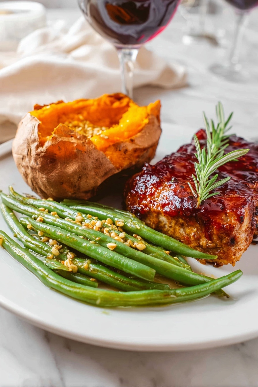The image shows a white plate with three food items arranged in separate sections. On the right side, there is a thick piece of grilled meat covered with a dark reddish glaze and garnished with a small sprig of green rosemary on top. In the center-left, there is a baked sweet potato, opened to show its bright orange, soft inside. In front of the sweet potato, there is a pile of green beans coated with small mustard seeds and a light sauce, giving them a slightly glossy look. The plate is set on a white marbled surface with blurred background elements including a glass of red wine and white fabric. photo taken with an iphone --ar 2:3 --v 7 - Green Beans with Mustard Butter Sauce, green beans side dish, quick vegetable recipes, easy green bean recipes, flavorful green bean side
